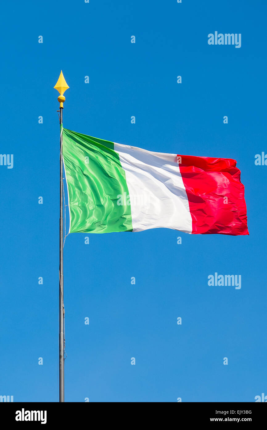 Bandiera Italiana sventolare nel vento con sottofondo di splendido cielo blu chiaro, giornata soleggiata, composizione verticale Foto Stock