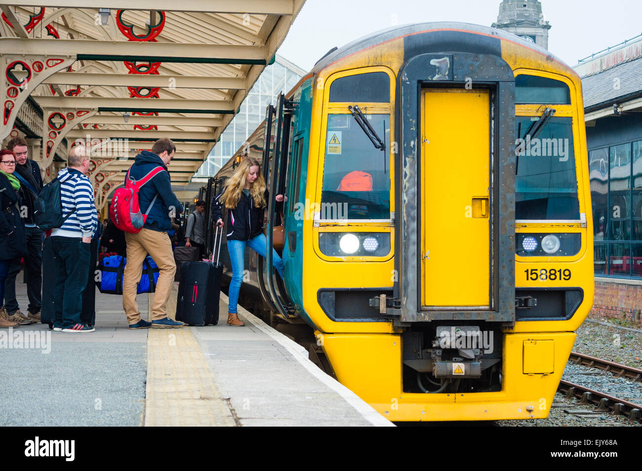 Trasporto pubblico: Gli Studenti Universitari per andare a casa di salire a bordo di un Galles arriva il treno a Aberystwyth stazione ferroviaria alla fine del termine accademico, Marzo 2015 Foto Stock