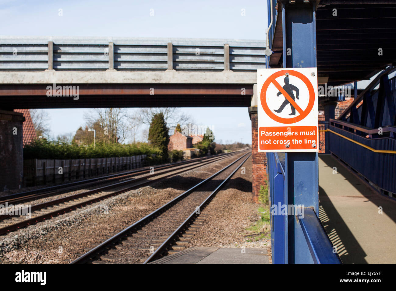 Regno Unito stazione ferroviaria segno che indica che "i passeggeri non devono attraversare la linea' Foto Stock