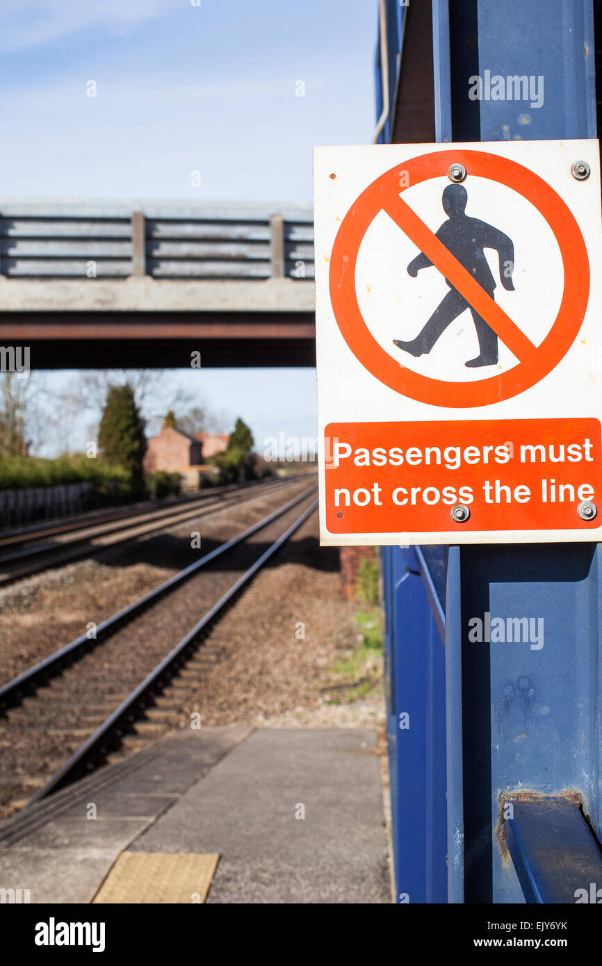 Regno Unito stazione ferroviaria segno che indica che "i passeggeri non devono attraversare la linea' Foto Stock