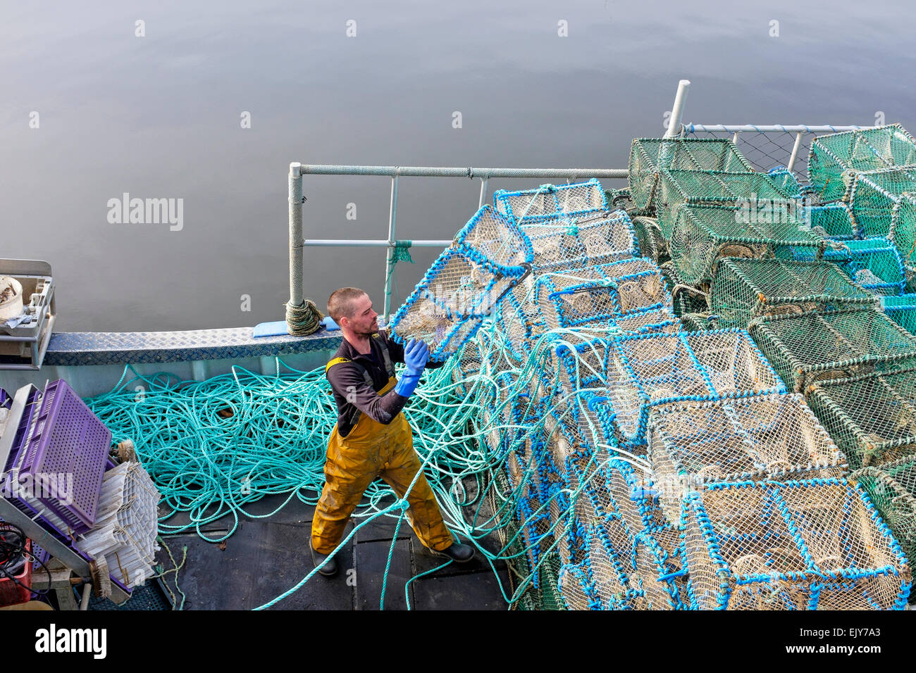 Neil McCulloch, pescatore di gamberi, caricando la sua barca da pesca con reti prima di uscire per andare a pesca nel Firth of Clyde, Greenock Foto Stock