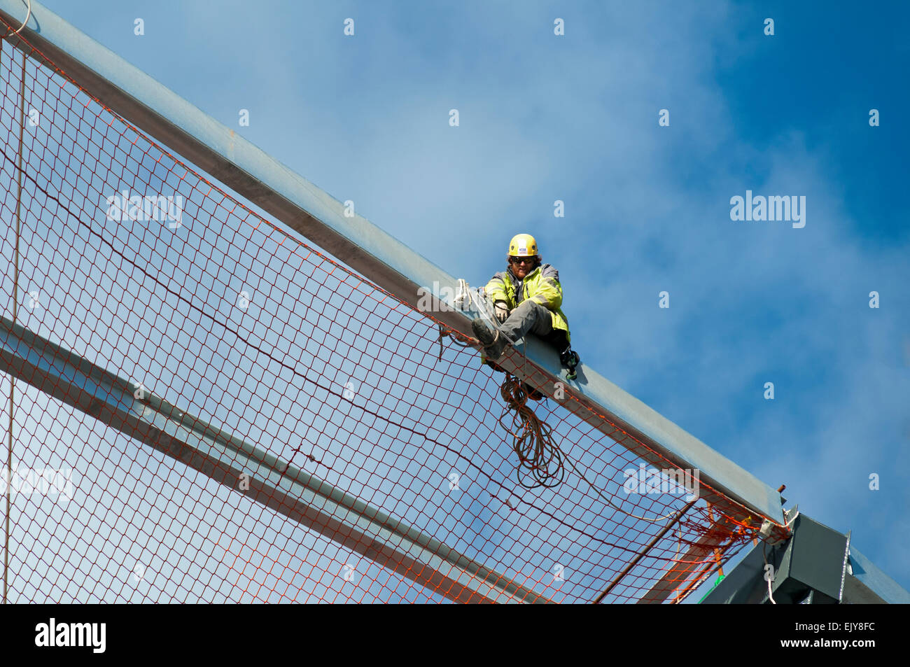 Workman fissaggio rete di sicurezza sul tetto dell'Etihad Stadium, South Stand progetto di espansione, Manchester, Inghilterra, Regno Unito Foto Stock
