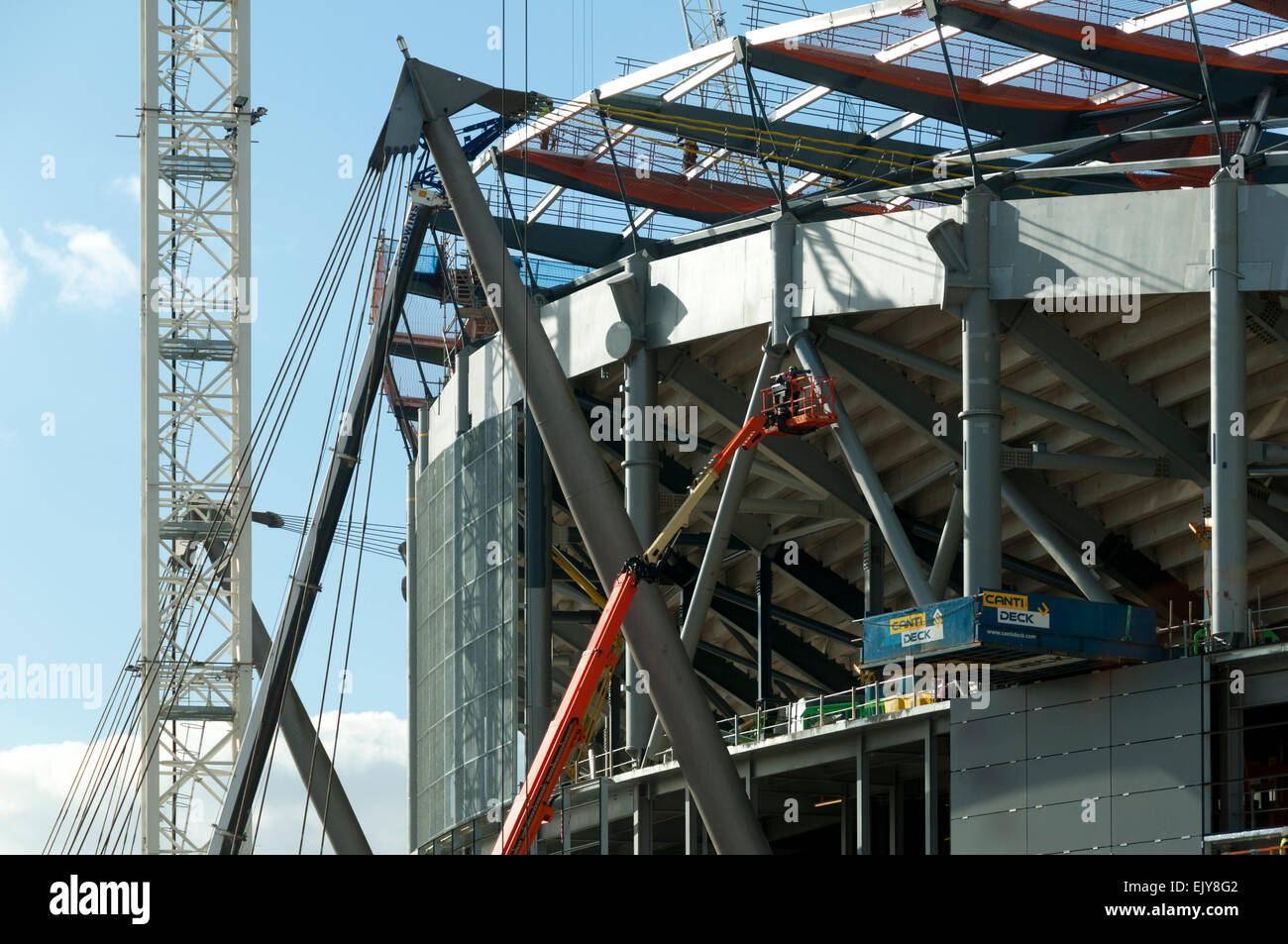 Workman su una piattaforma di accesso, lo Stadio Etihad, South Stand progetto di espansione, Manchester, Inghilterra, Regno Unito Foto Stock