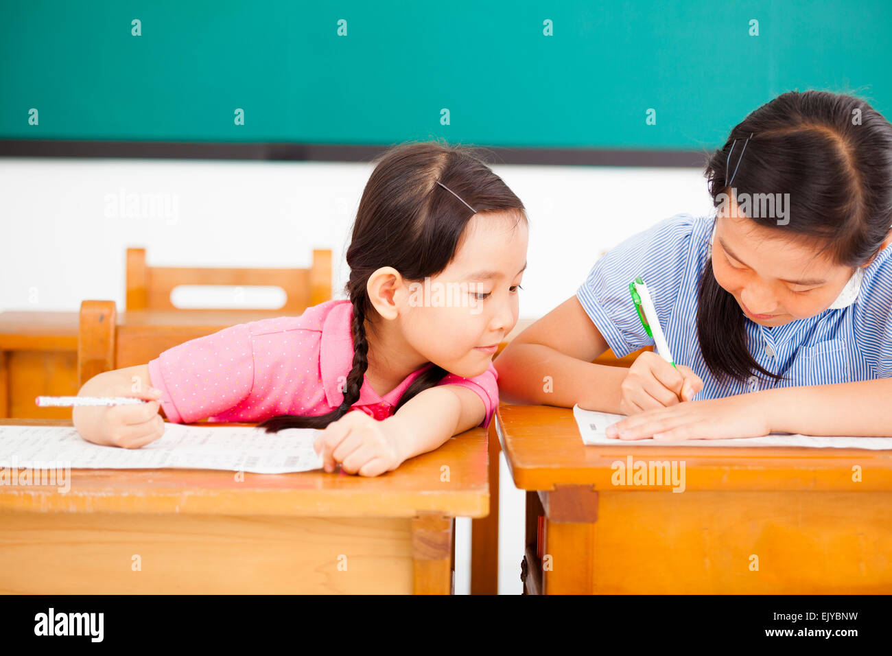 Bambina studente cercando di barare al test in classe Foto Stock