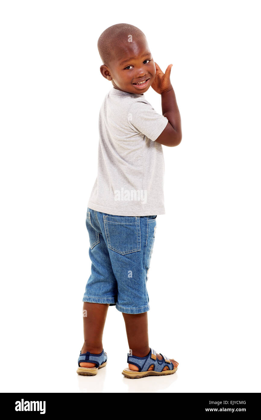 Carino piccolo African American boy guardando indietro isolate su sfondo bianco Foto Stock