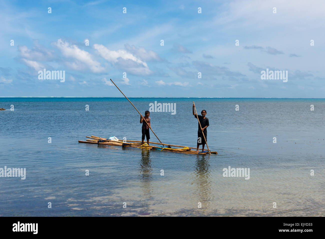I ragazzi di canottaggio zattera di bambù sull'oceano, Yap Island, Stati Federati di Micronesia Foto Stock