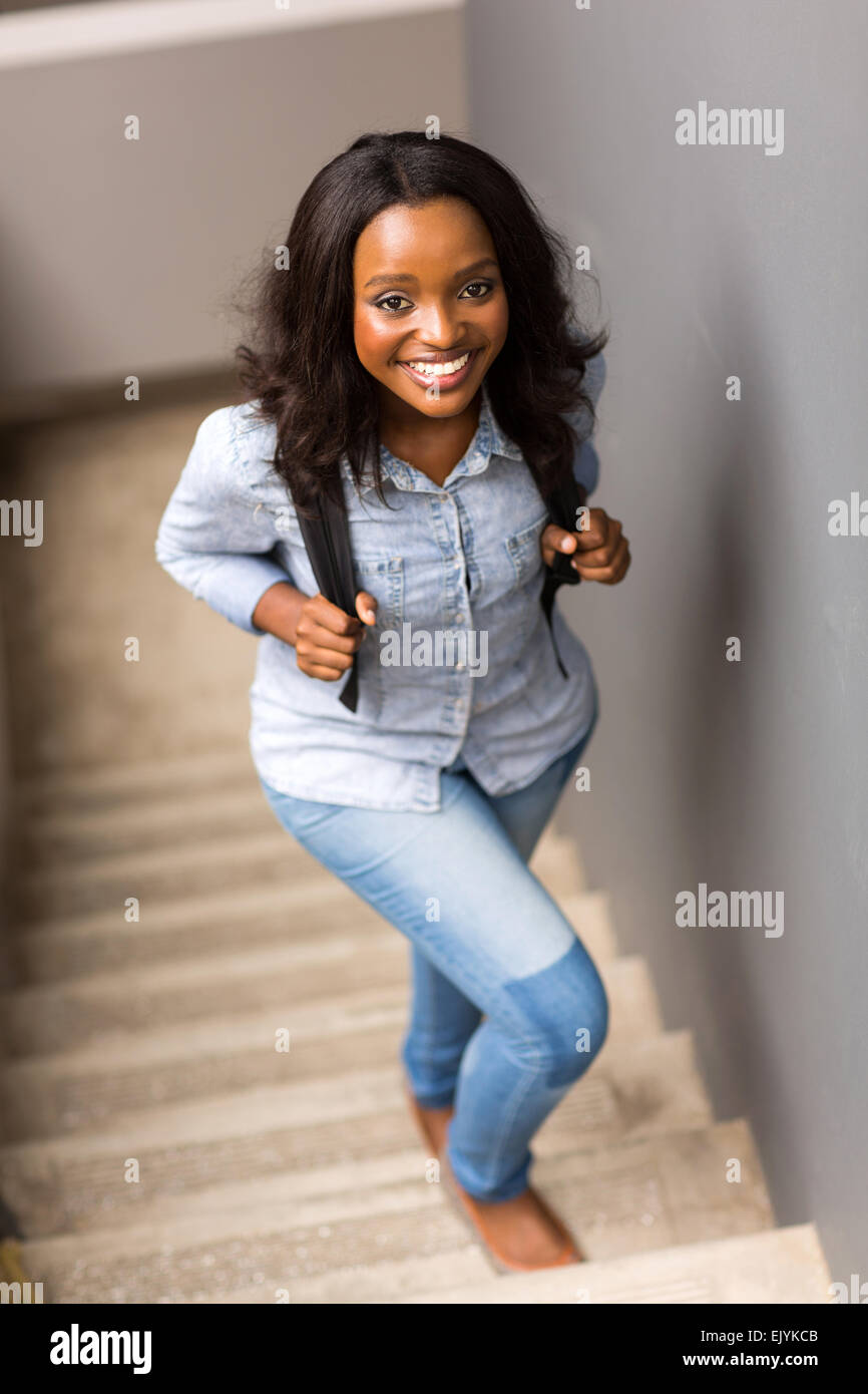 Bellissimo collegio africano ragazza camminare su per le scale fino al campus Foto Stock