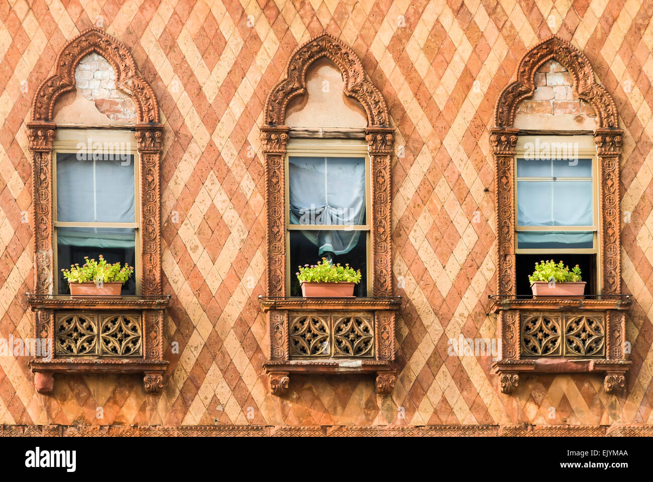 Un trio di decorativo windows veneziano circondato da ornati in cotto Foto Stock