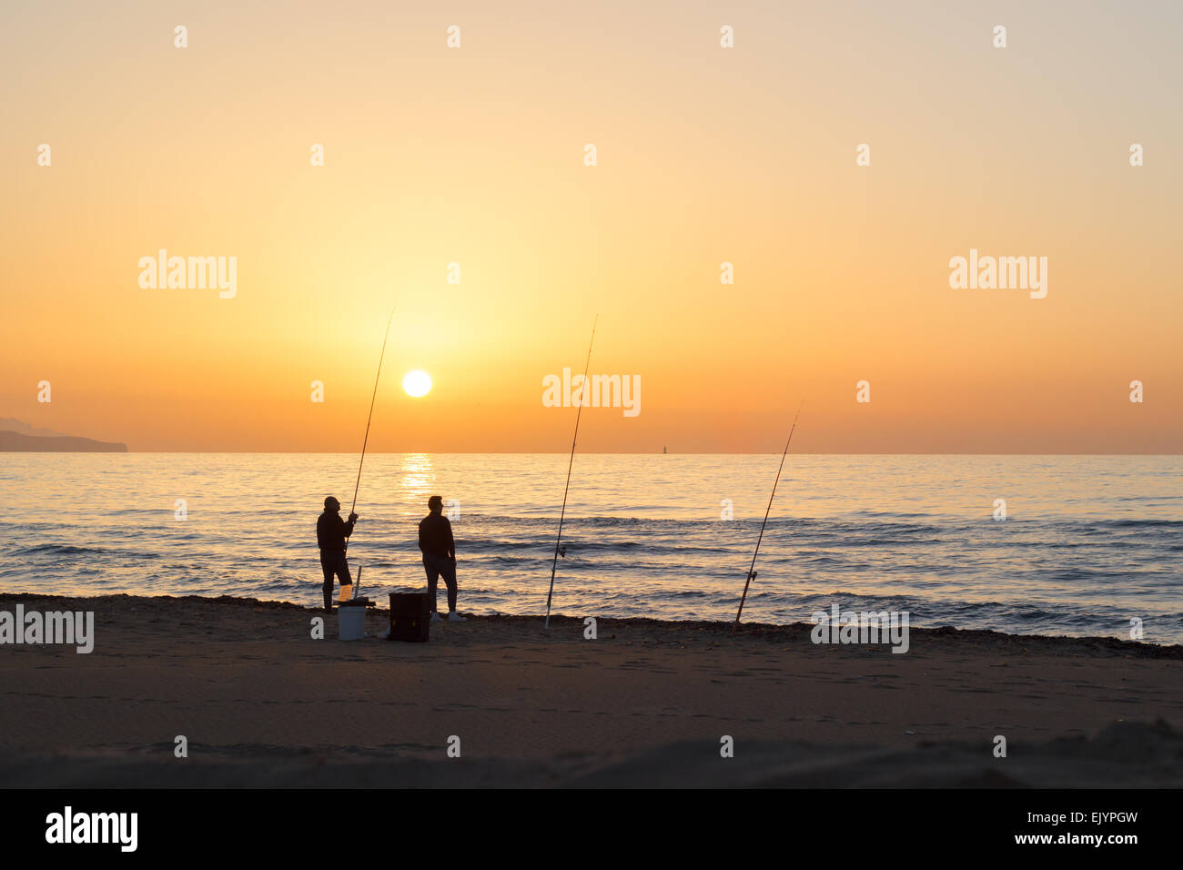 Persone sagome uomini pesca mare tramonto sun beach ocean Foto Stock