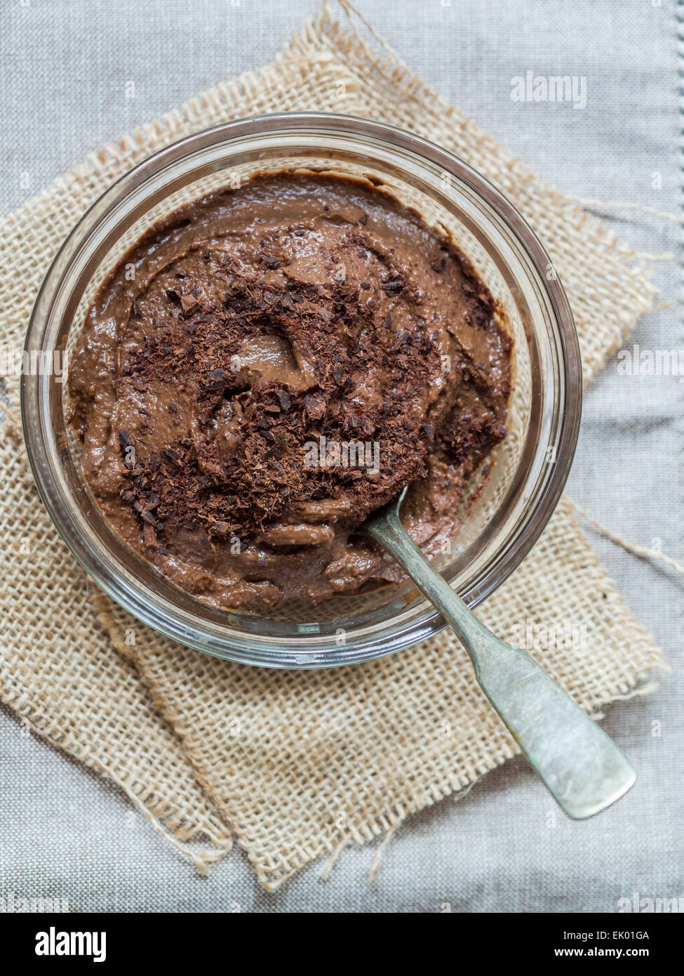 Vegan avocado mousse al cioccolato (pudding) in un recipiente di vetro, vicino. Orientamento verticale, vista da sopra. Foto Stock