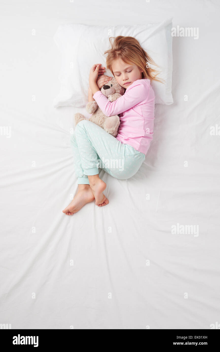 Vista superiore della bambina che dorme con Teddy bear Foto Stock