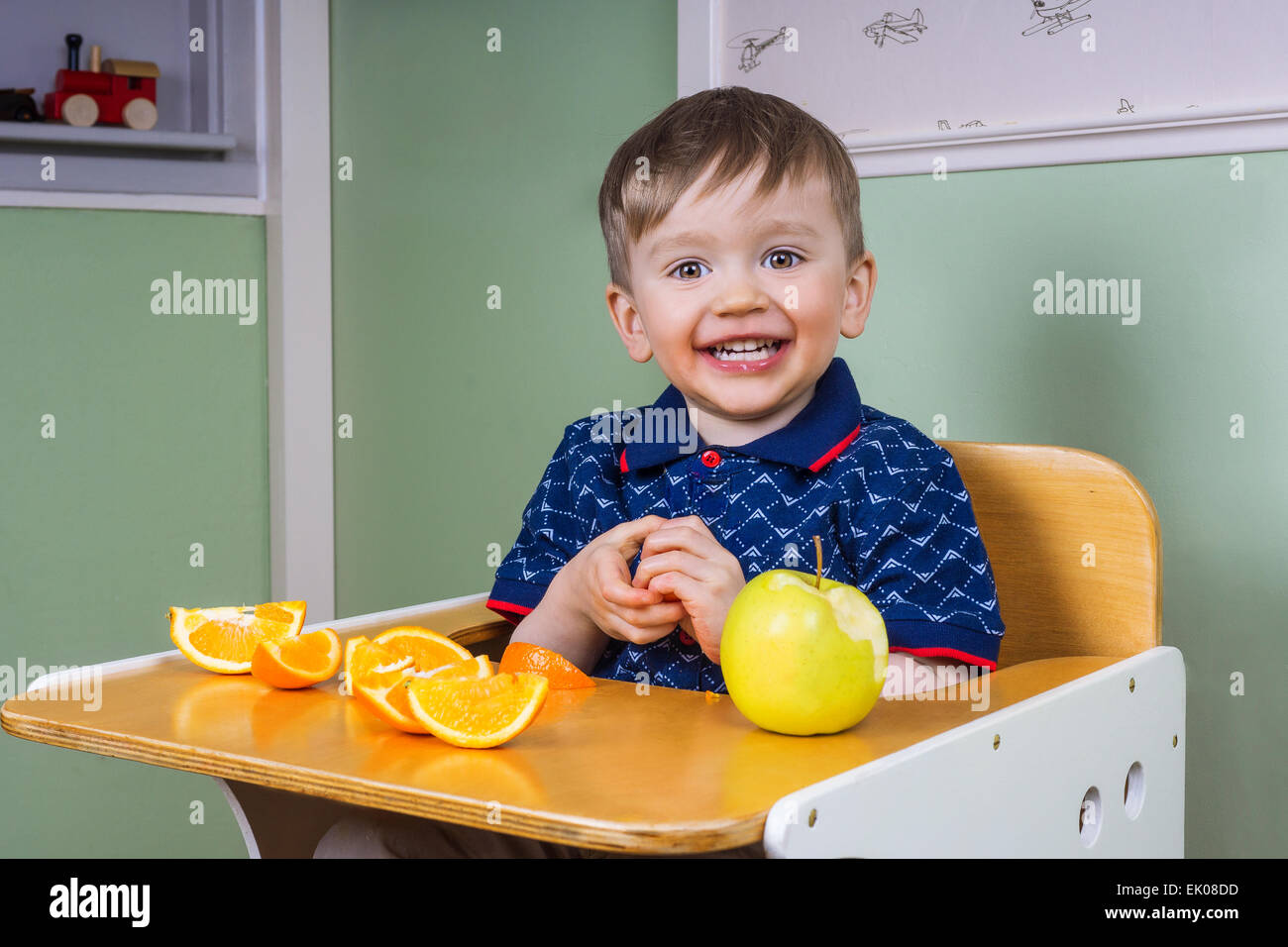Sorridente toddler mangiare la frutta Foto Stock