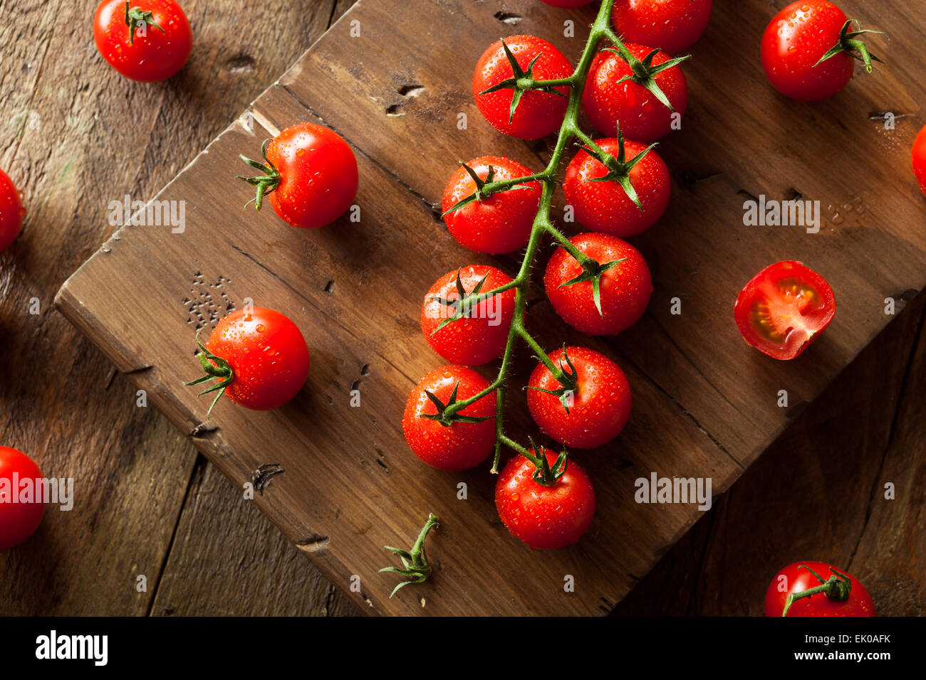 Raw rosso organico Pomodori ciliegia sulla vite Foto Stock