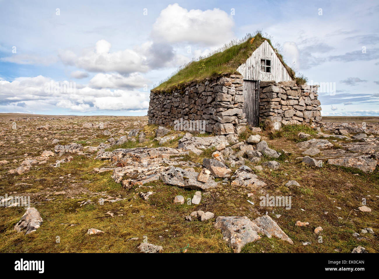 Vista di un tappeto erboso di pietra con tetto di casa rifugio nel Westfjords dell Islanda. Foto Stock