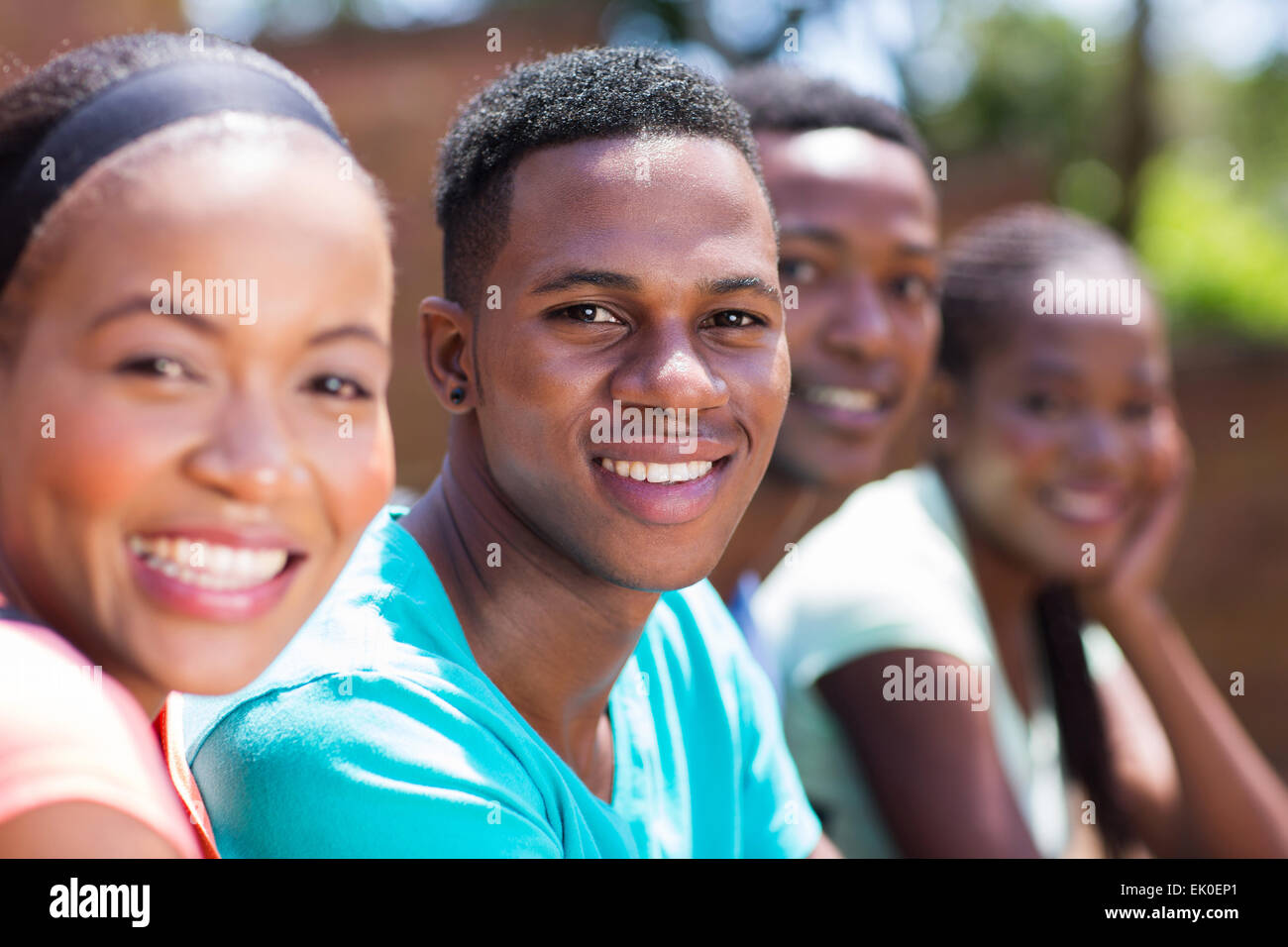 Bello Afro American college ragazzo seduto con gli amici Foto Stock