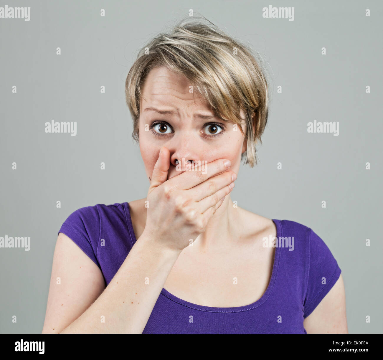 Giovane donna cercando disturbato da qualcosa, isolato su bianco Foto Stock