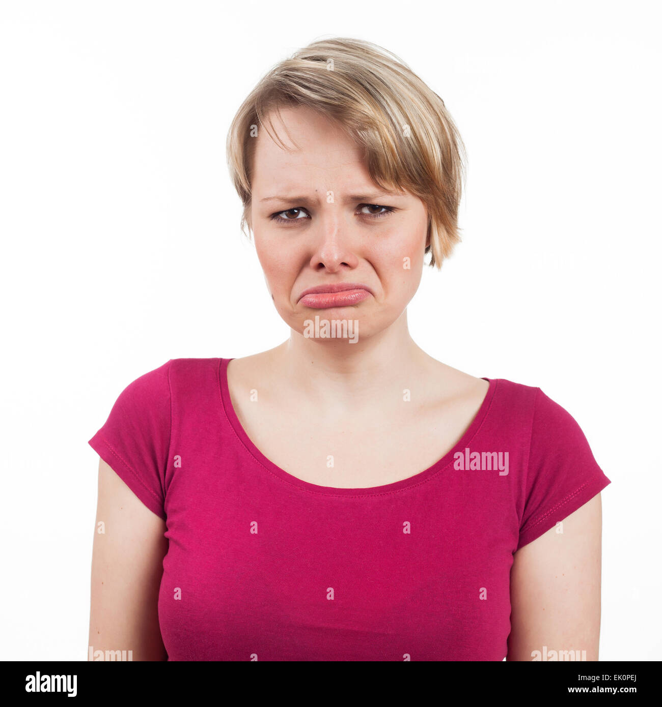 Giovane donna con un espressione infelice, isolato su bianco Foto Stock