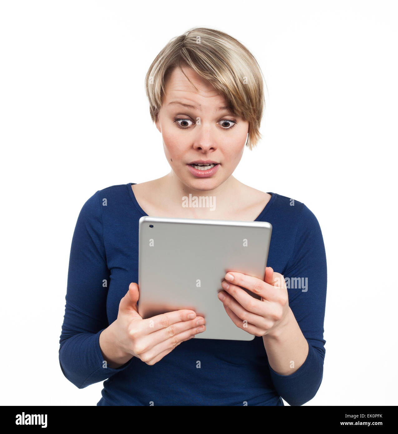 Giovane donna tenendo una tavoletta elettronica e guardando stupito, isolato su bianco Foto Stock