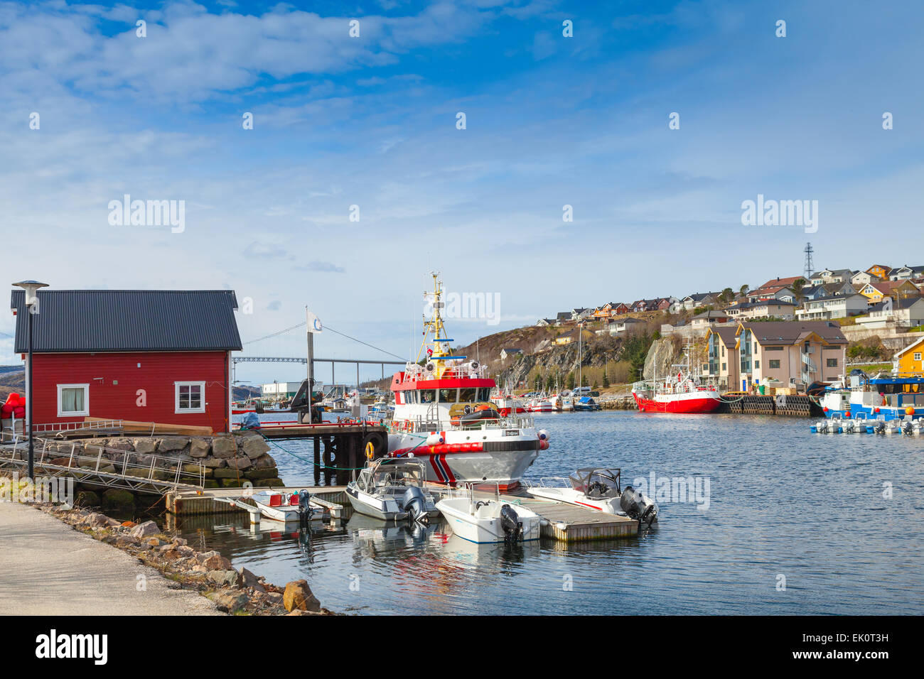 Piccolo villaggio norvegese paesaggio, case in legno e ormeggiate barche di pescatori sulla costa del mare del Nord Foto Stock