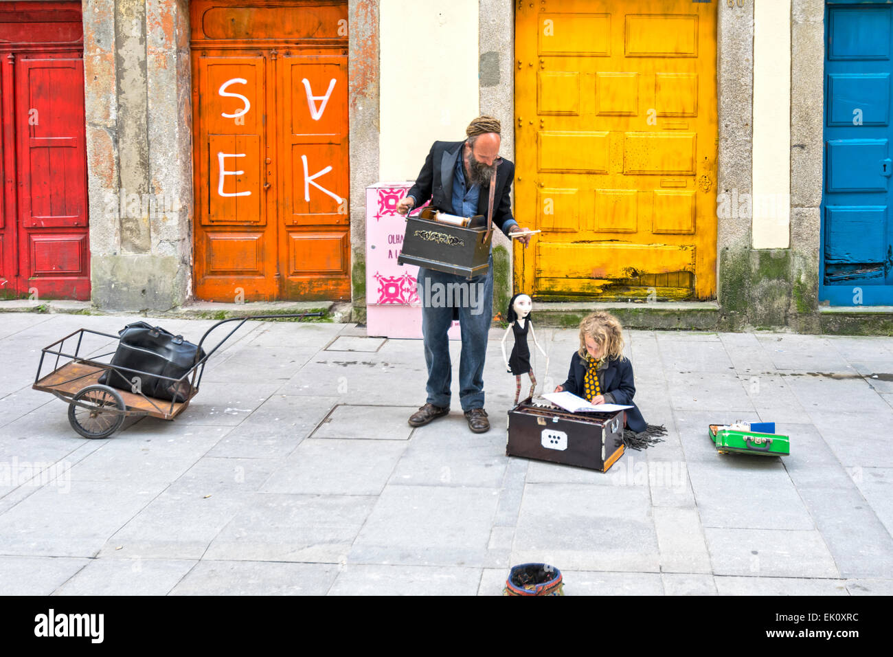 Portogallo PORTO STREET PERFORMER con musica e un burattino e il bambino a leggere un libro sul marciapiede Foto Stock