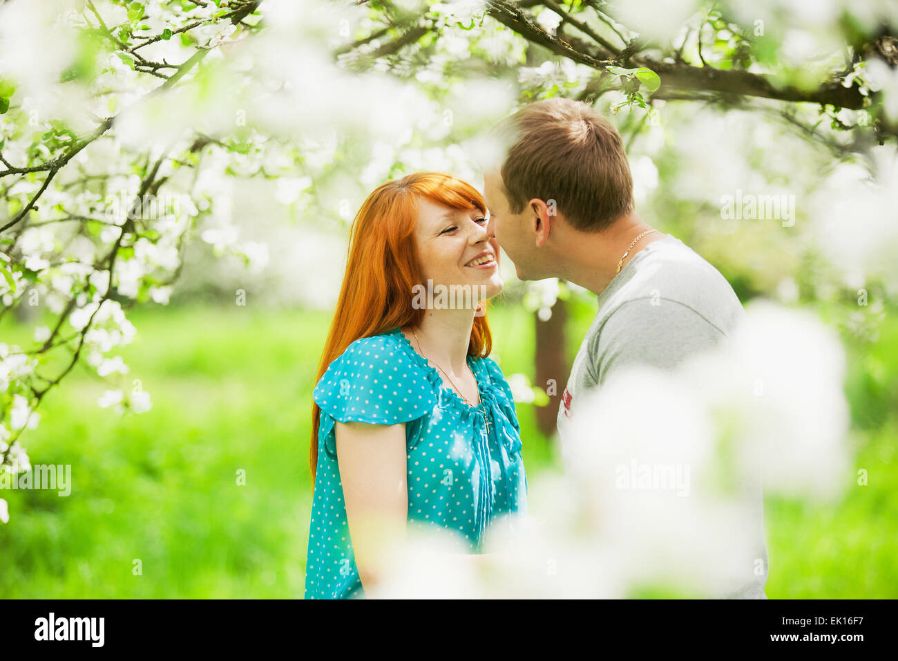 Bella giovane in amore divertimento all'aperto nella primavera del giardino pieno di fioritura apple-alberi Foto Stock