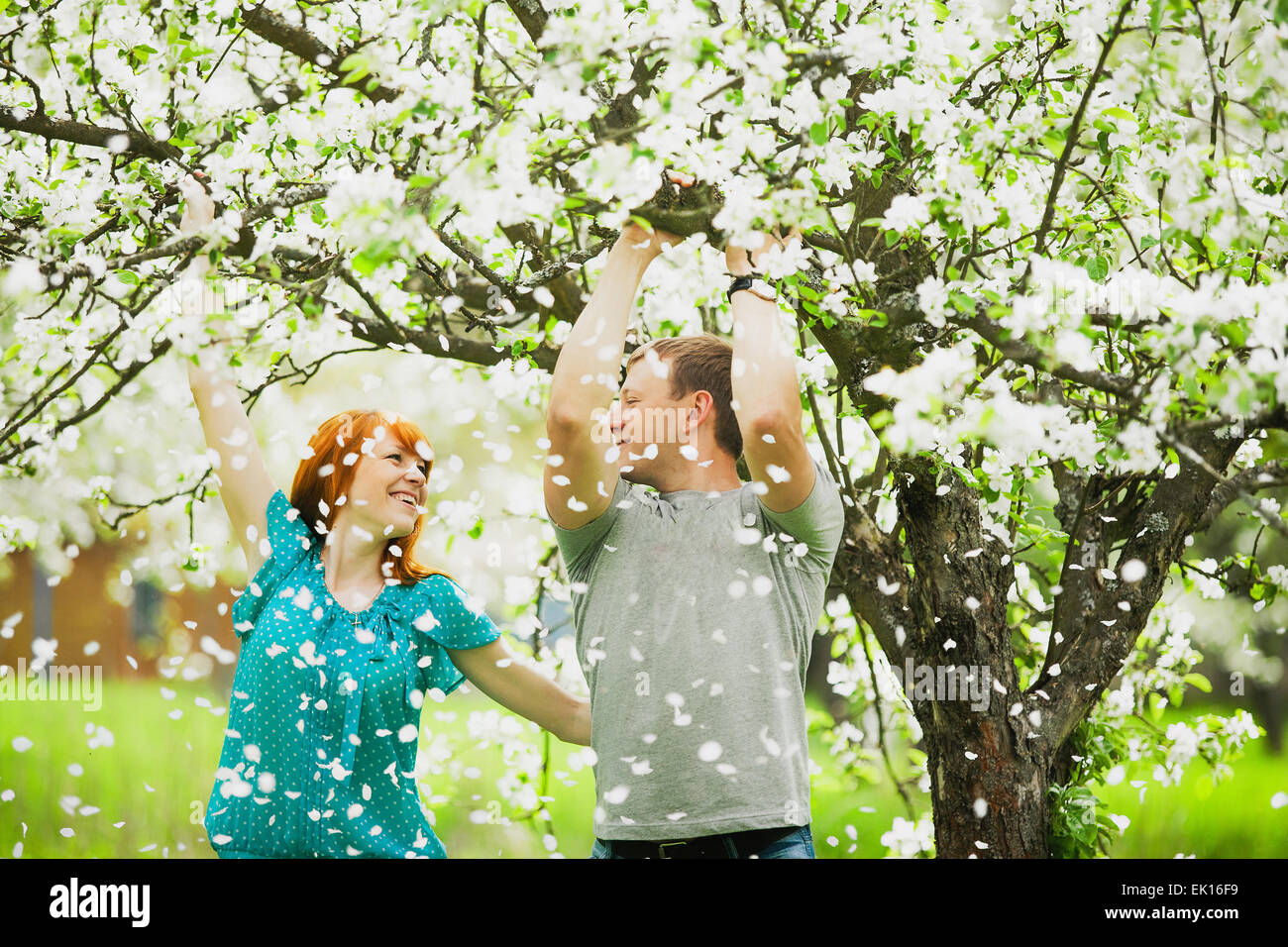 Bella giovane in amore divertimento all'aperto nella primavera del giardino pieno di fioritura apple-alberi Foto Stock