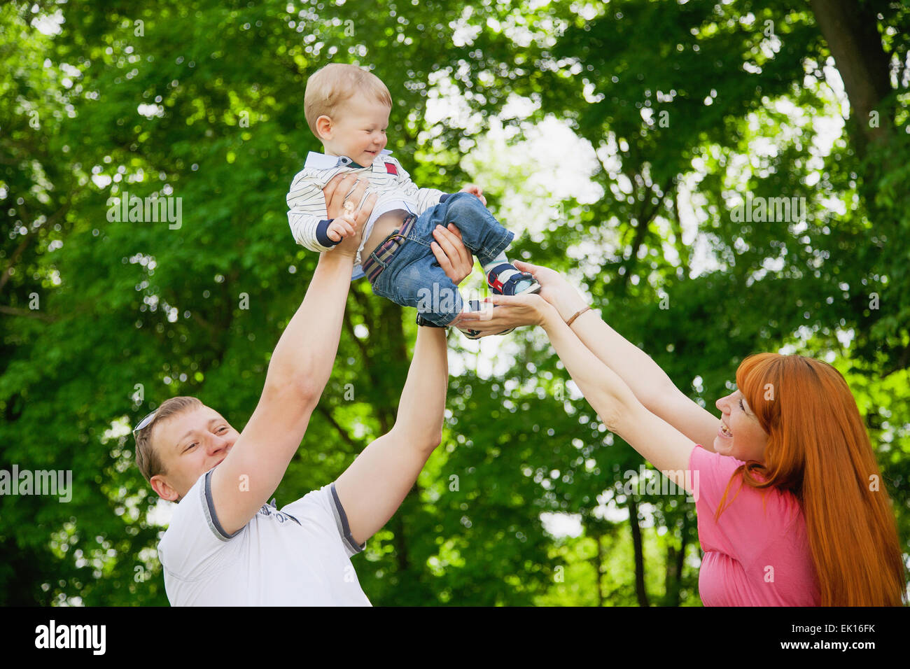 La famiglia felice avendo divertimento all'aperto nel parco. Il padre, la madre e il bambino. Concetto di famiglia Foto Stock