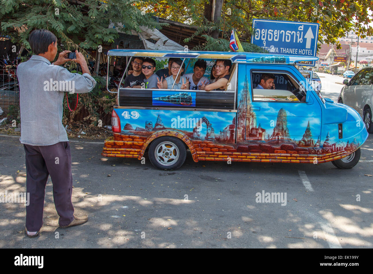 Un uomo di scattare una foto di un gruppo di turisti cinesi su un tuk tuk Foto Stock
