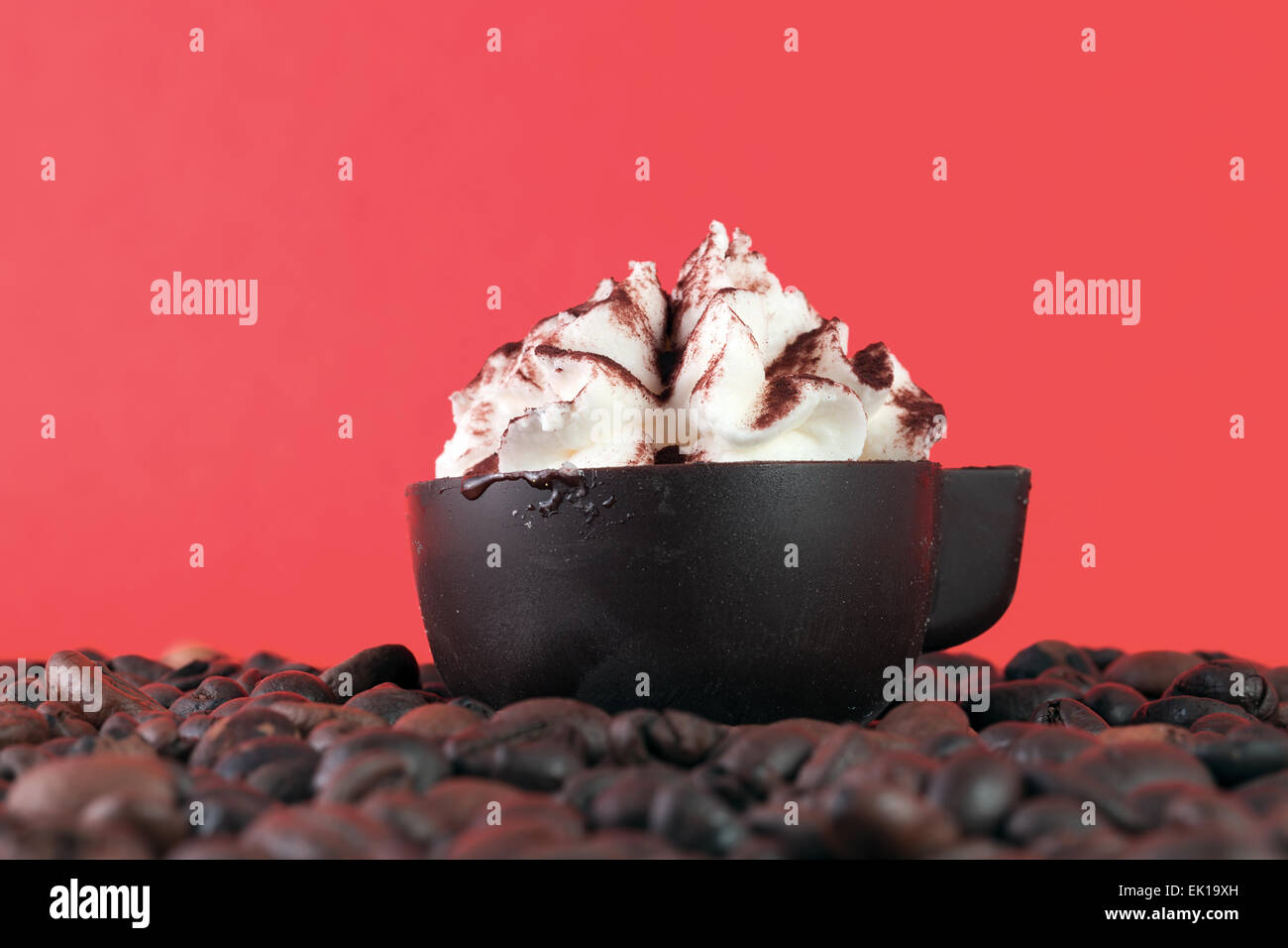 Uovo flip sul caffè in grani su sfondo rosso Foto Stock