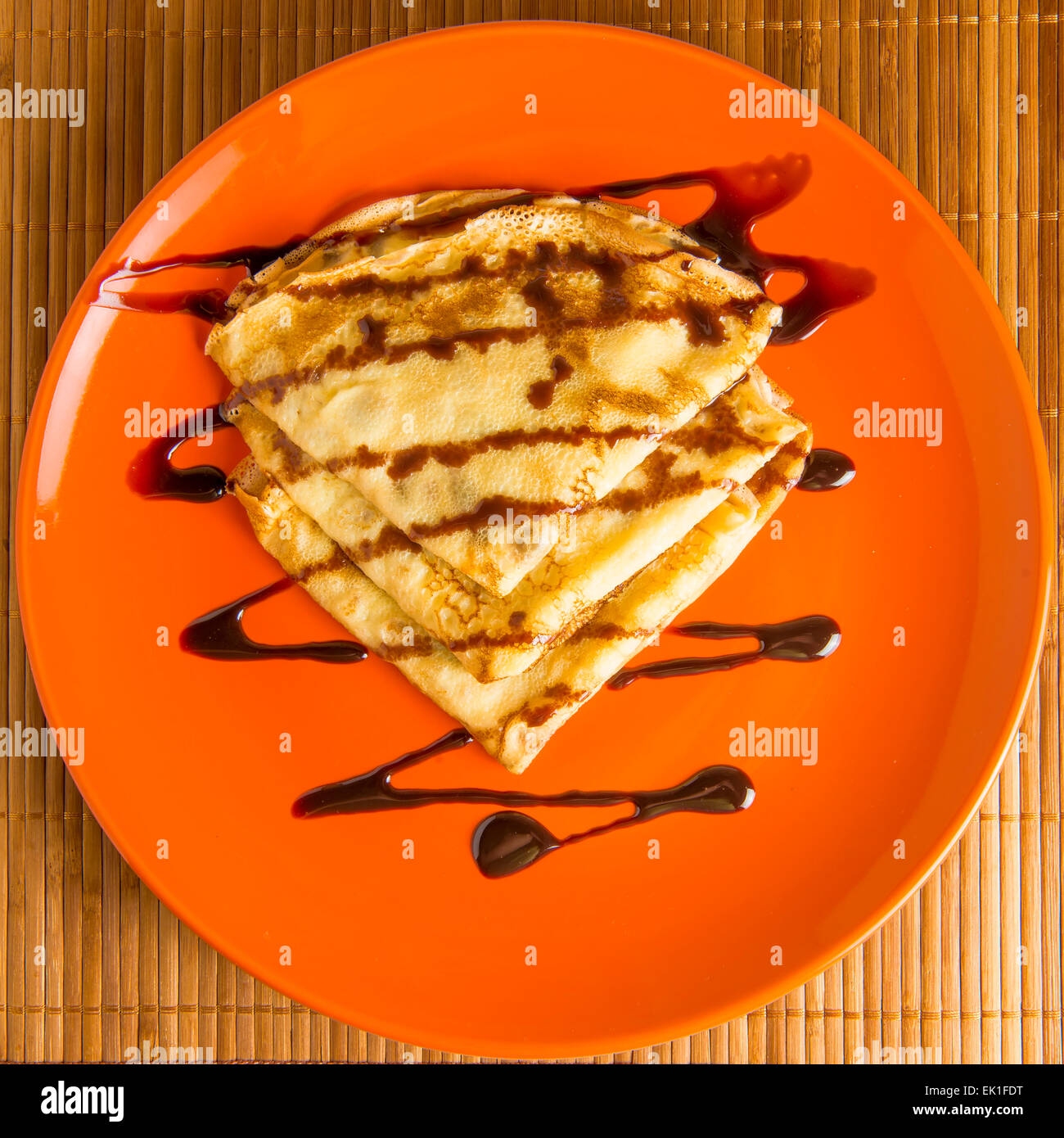 Deliziose frittelle su una piastra arancia annacquato il cioccolato Foto Stock