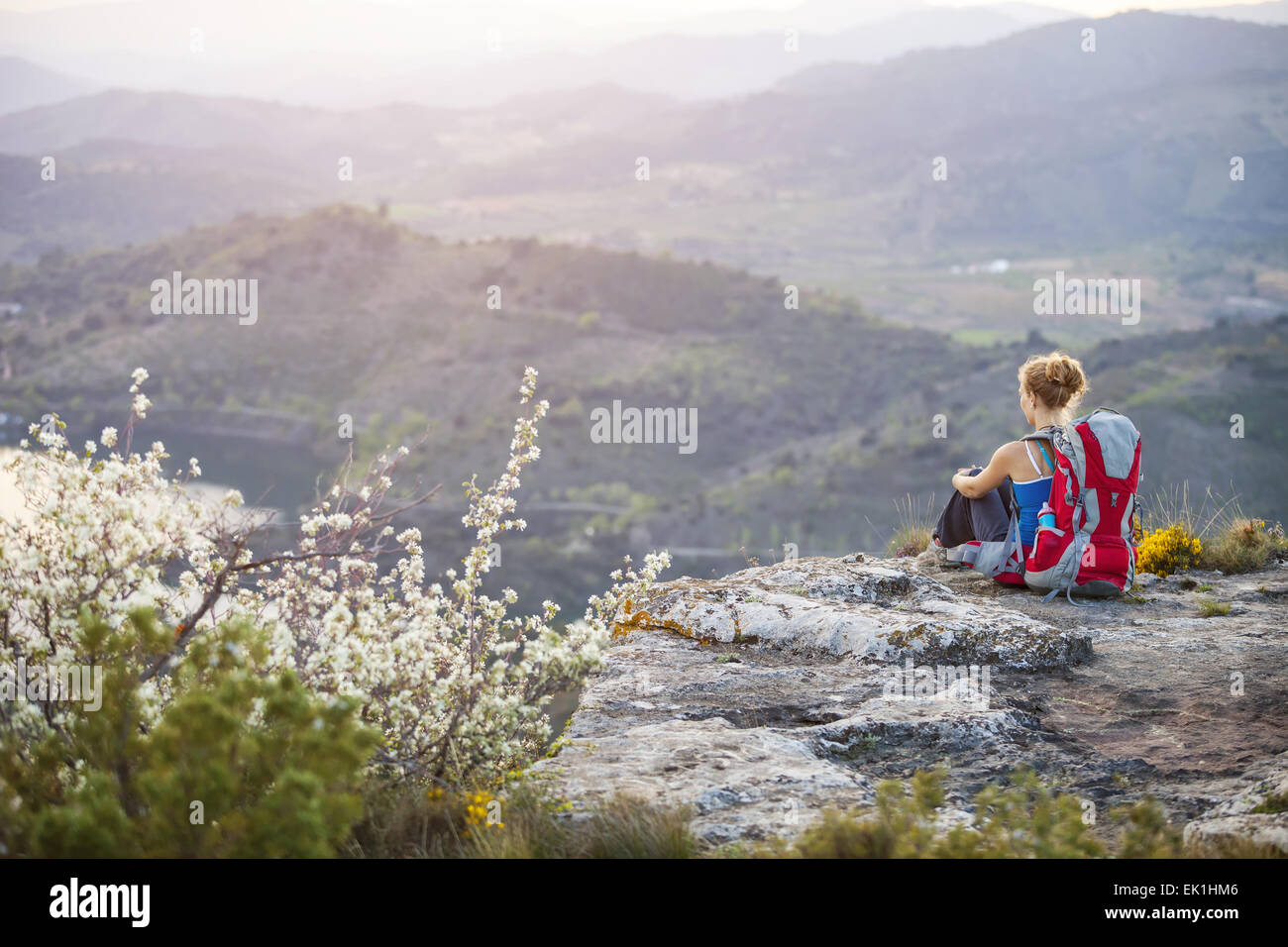 Donna seduta turistica sulla cima di una montagna Foto Stock