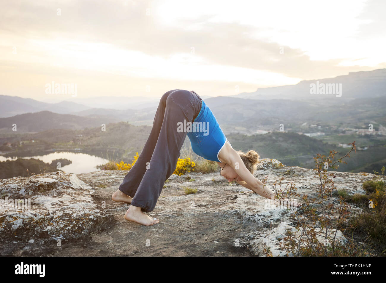Giovane donna caucasica eseguendo il cane verso il basso lo yoga pone all'aperto Foto Stock