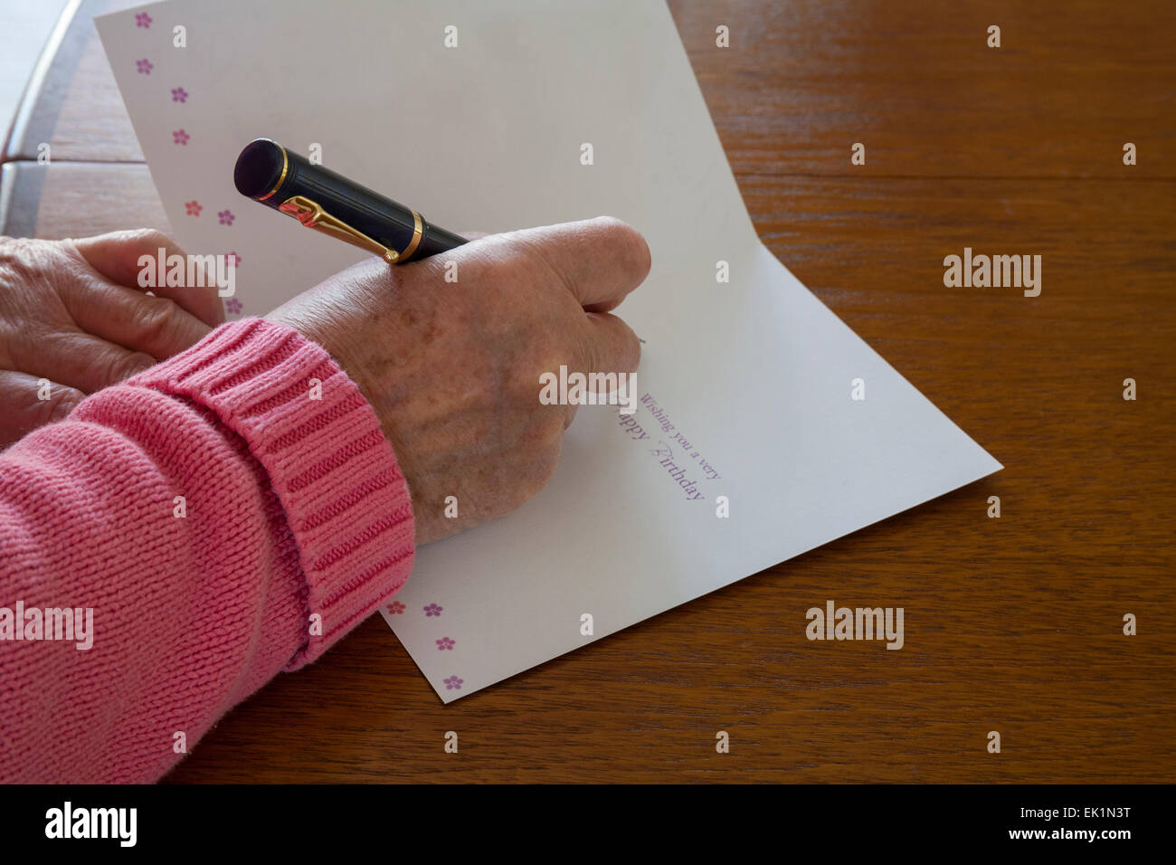 Close up donna anziana con penna stilografica per scrivere saluti sul  biglietto di auguri di compleanno Foto stock - Alamy