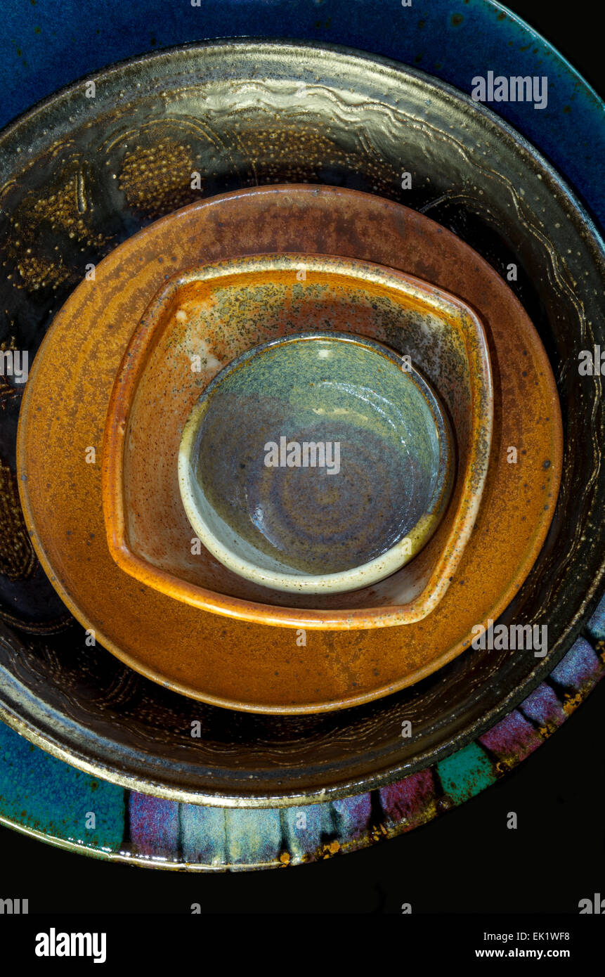 Colorata a mano di ceramica ciotole piattino e servire piatto impilati all'interno di ciascun altro Foto Stock