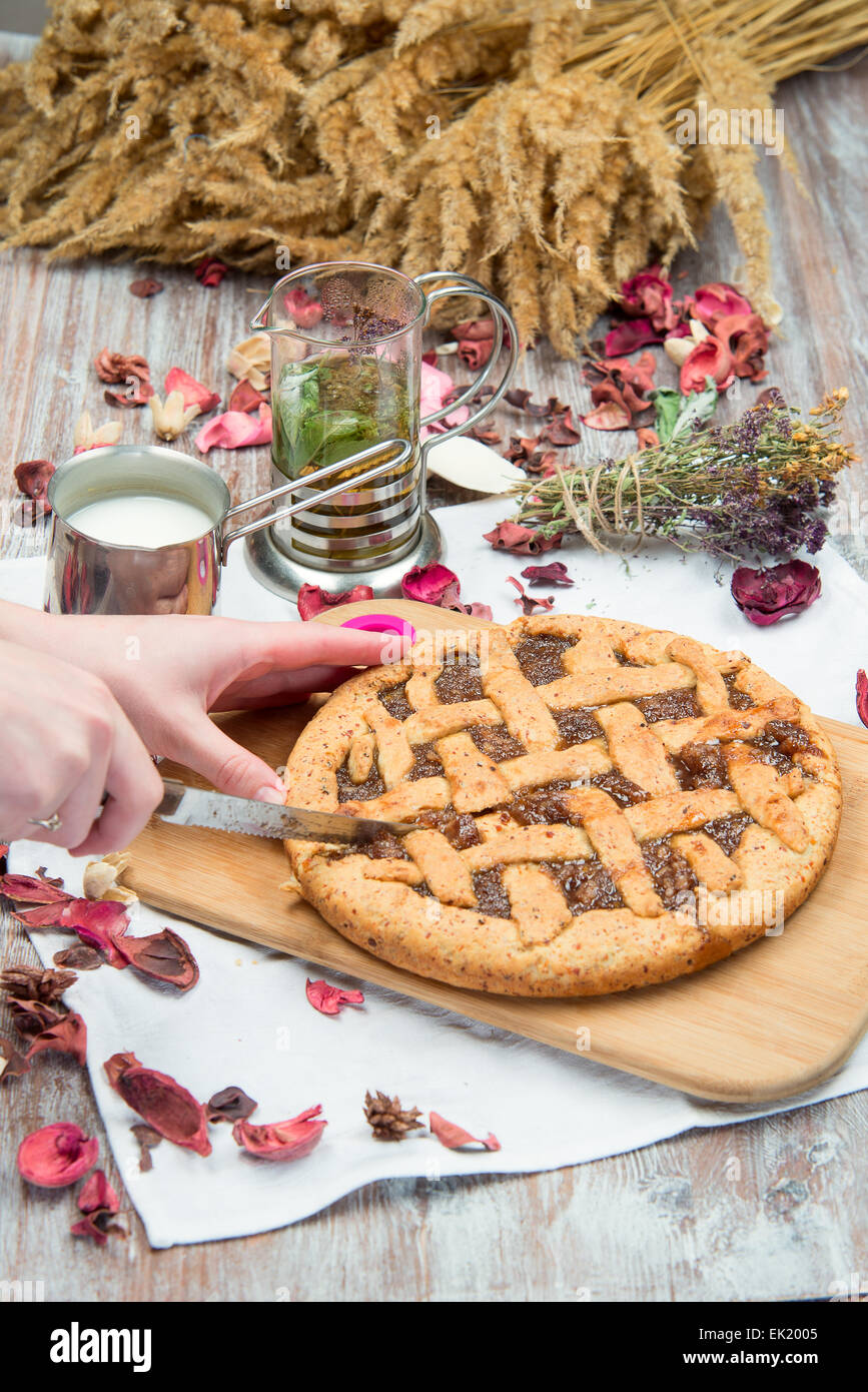 Torta rustica è sulla scheda su uno sfondo di tazze di tè e latte Foto Stock