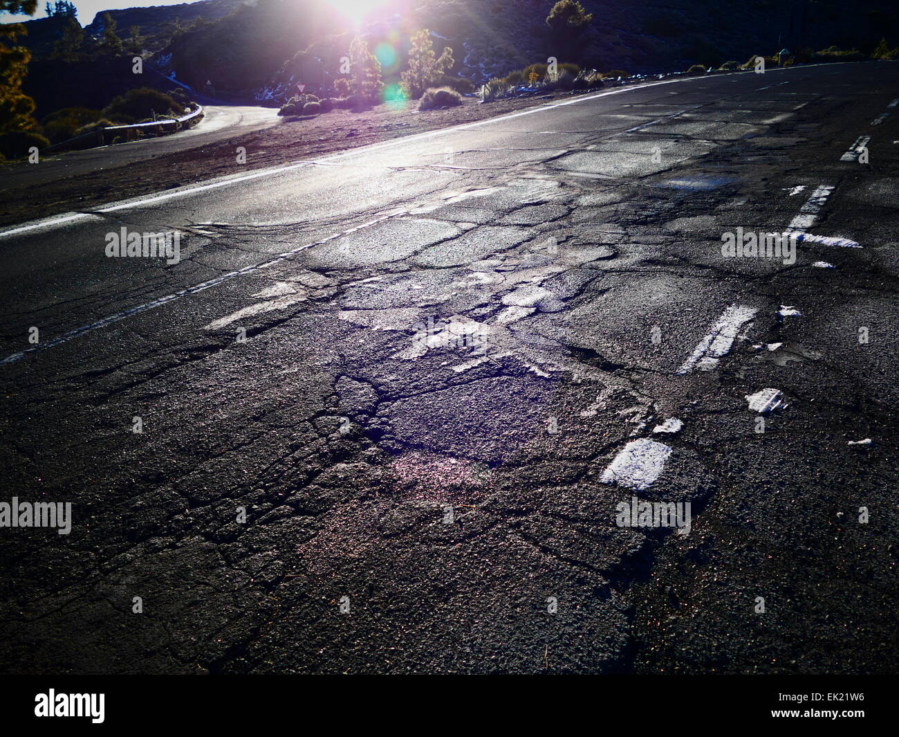 Rotture di asfalto danneggiato dalla luce del sole caldo. Il monte Teide Parque Nacional del Teide Tenerife Isole Canarie Spagna Foto Stock