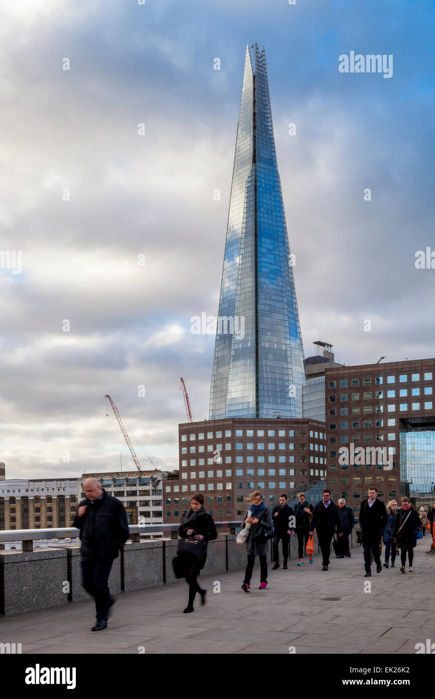 Le persone che attraversano il London Bridge sul loro modo di lavorare nella City di Londra, Londra, Inghilterra Foto Stock