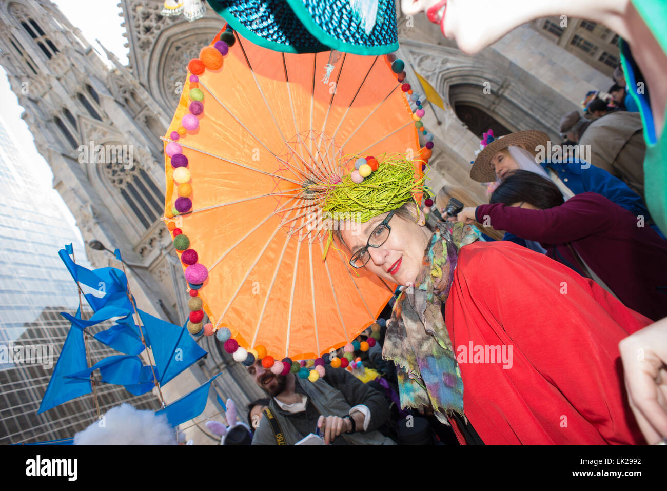 Elegante e alla moda donna che indossa un arancione e verde cofano Pasqua passeggiate in Easter Parade su Manhattan Fifth Avenue Foto Stock