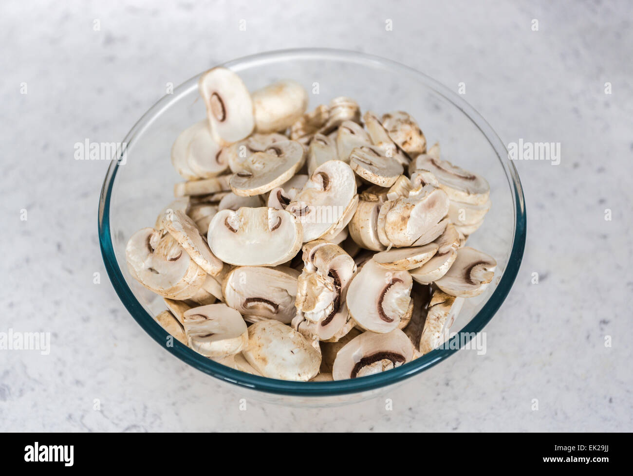 Home ingredienti di cucina - un bicchiere o una ciotola di pyrex di materie non cotti preparati fette di funghi prataioli pronto per l'uso in cucina Foto Stock