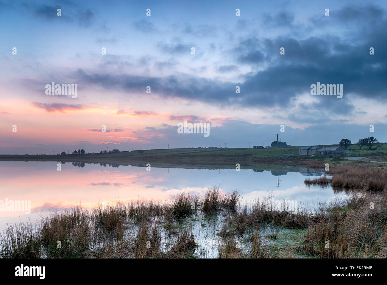 Drammatico tramonto a Dozmary Pool un punto di riferimento storico immerso nella leggenda arturiana in Bodmin Moor in Cornovaglia Foto Stock