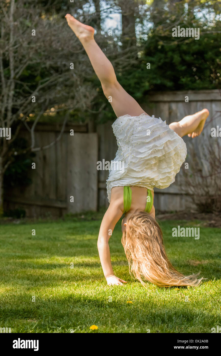 7 anno vecchia ragazza che mostra off eseguendo una appoggiate nel suo cortile in Issaquah, Washington, Stati Uniti d'America Foto Stock