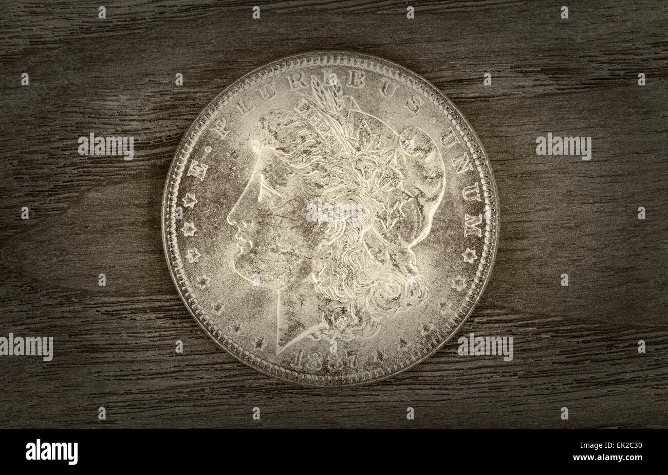 Vintage concetto di Silver Dollar in ottime condizioni su legno invecchiato. Lieve vignette bordo attorno alla moneta. Foto Stock