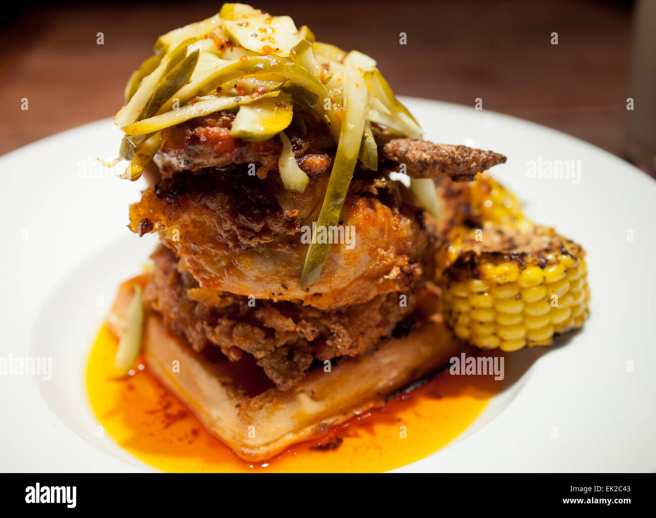Soul food: un pollo gourmet e waffle piatto e rabboccato con aneto sottaceti Dal Bon Temps Cafe di Saskatoon, Saskatchewan, Canada. Foto Stock