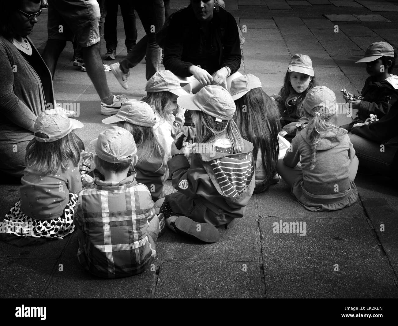 Germania Monaco di Baviera Marienplatz Kindergarten Kids sul pavimento avente panini pranzo Foto Stock