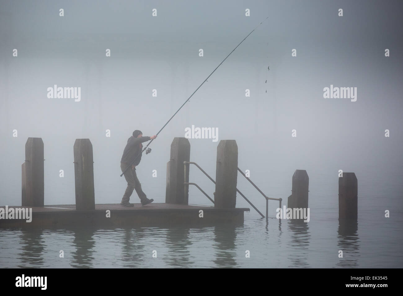 Aberystwyth, Wales, Regno Unito. Il 6 aprile 2015. Il Lunedì di Pasqua. Meteo. Un pescatore di preparazione al cast di un pontile in legno in una fitta nebbia di mare. Aberystwyth pier debolmente visibile dietro. Credito: Alan Hale/Alamy Live News Foto Stock