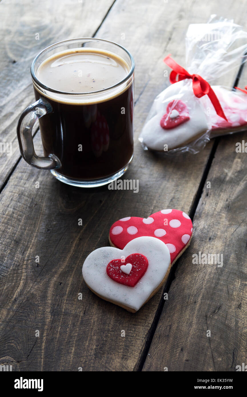 Cuore di panpepato e caffè sul legno rustico sfondo. Retroilluminati Foto Stock