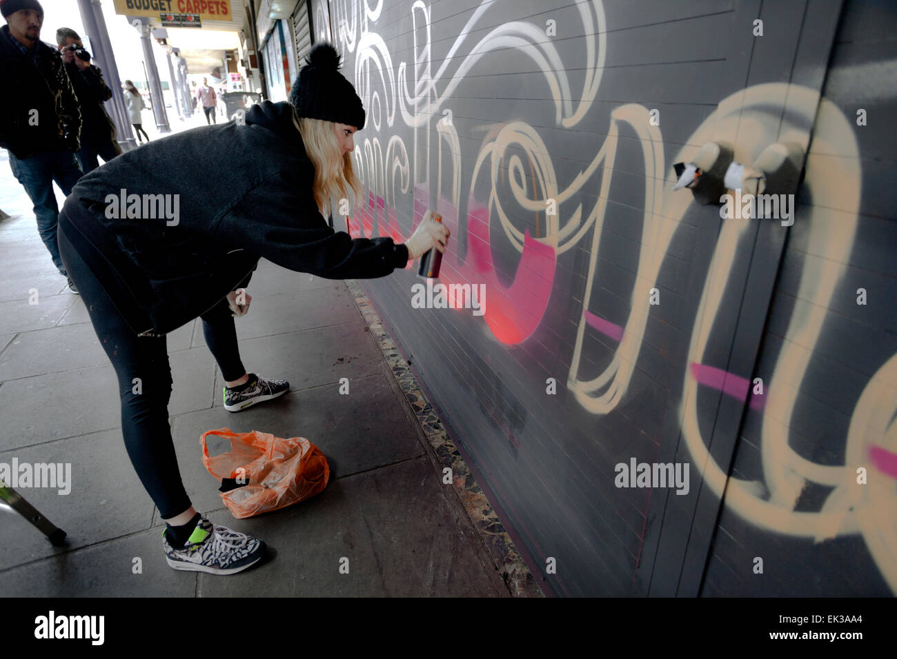 Brixton, Londra, Regno Unito. 06 apr, 2015. Lucinda Irlanda aka Lilly Lou dipinge un murale su uno dei negozi che la guida della rete intende sfrattare dalla stazione archi su Atlantic Road. Il progetto è organizzato da perni come parte del salvare Brixton archi campagna. Credito: Miele Salvadori/Alamy Live News Foto Stock