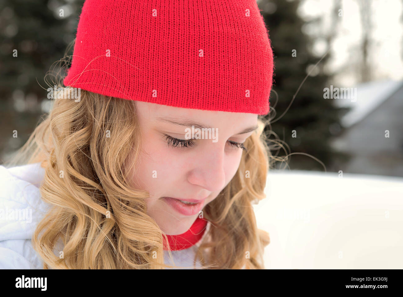 Caucasian ragazza adolescente che indossa un inverno rosso cappuccio all'aperto Foto Stock