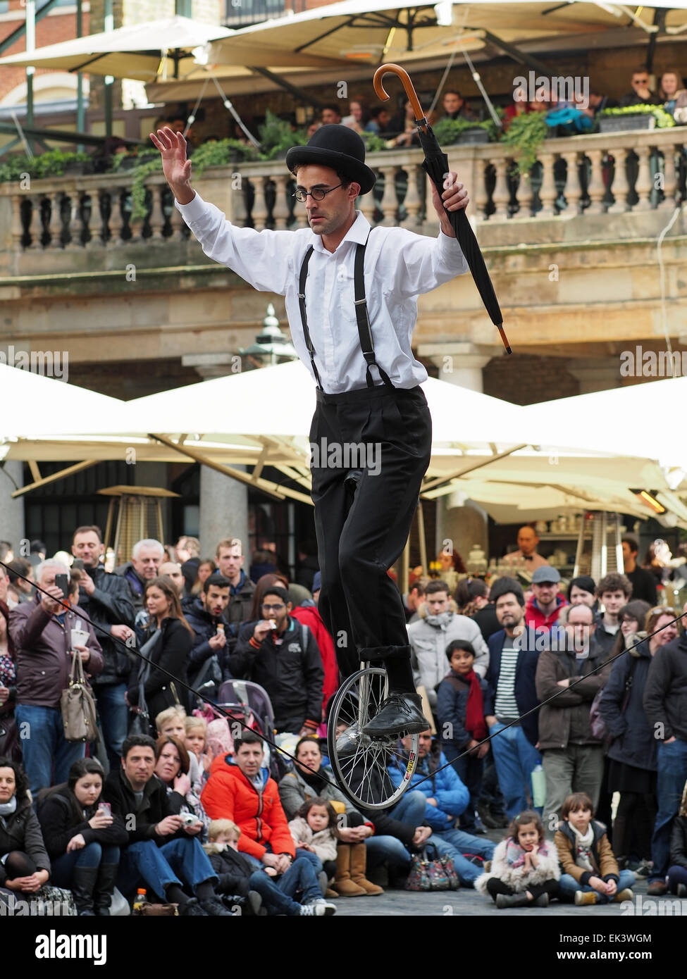 Un funambolo su un monociclo intrattenere una folla in Covent Garden London REGNO UNITO Foto Stock