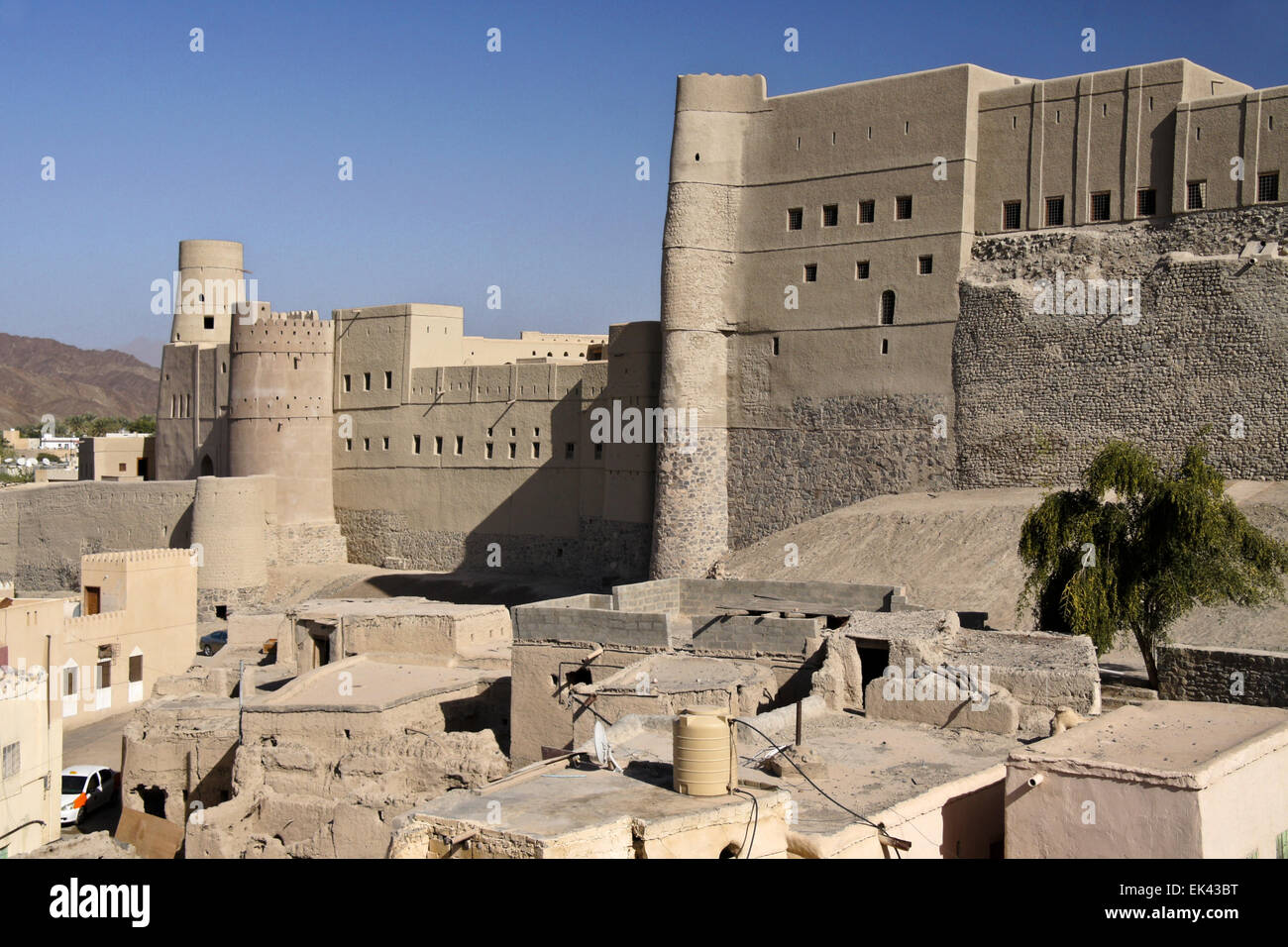 Bahla (Bahala) Fort e vecchie case mudbrick sotto i merli, il sultanato di Oman Foto Stock